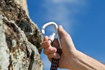 Close-up of a hand using a carbine and hook to climb a wall