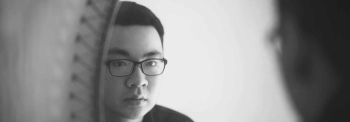 monochrome photography of a man looking in front of mirror