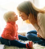 woman and child sitting on fur covered bed