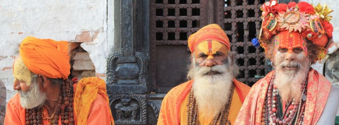 three men wearing orange tradition clothes