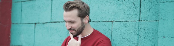man in red long sleeve shirt using gray laptop computer